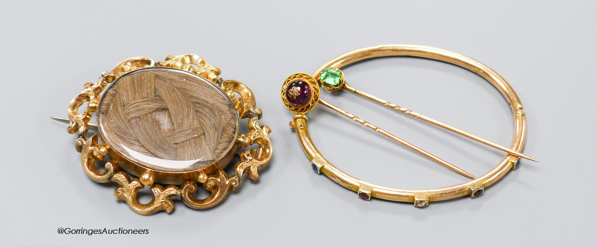 A Victorian yellow metal oval mourning brooch, with glazed panel above plaited hair, 57mm, gross 20.9 grams, a 9ct, ruby, sapphire and diamond set five stone hinged bangle (dents), gross 7.4 grams and two gem set stick p